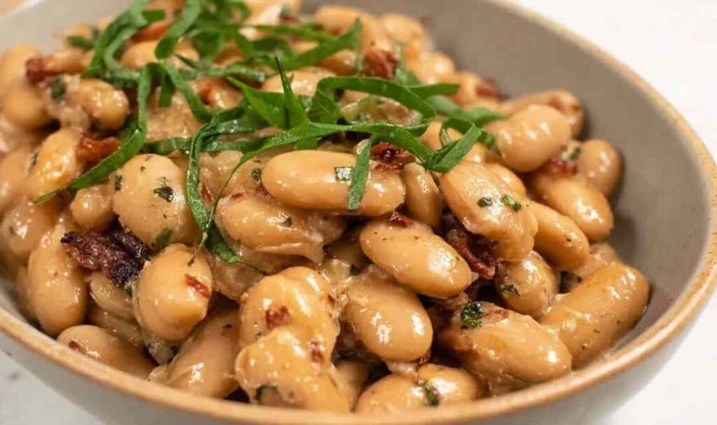 Tuscan Marry Me Butter Beans in a skillet with creamy sun-dried tomato sauce and fresh basil