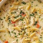 Bowl of white chicken lasagna soup topped with melted mozzarella and fresh parsley