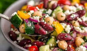 Zesty Mediterranean bean salad with chickpeas, feta, olives, and fresh herbs in a large white bowl