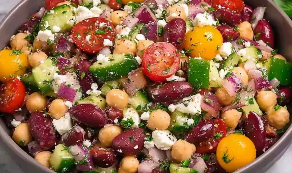 Zesty Mediterranean Bean Salad with Feta 5 Zesty Mediterranean bean salad with chickpeas, feta, olives, and fresh herbs in a large white bowl