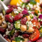 Zesty Mediterranean bean salad with chickpeas, feta, olives, and fresh herbs in a large white bowl