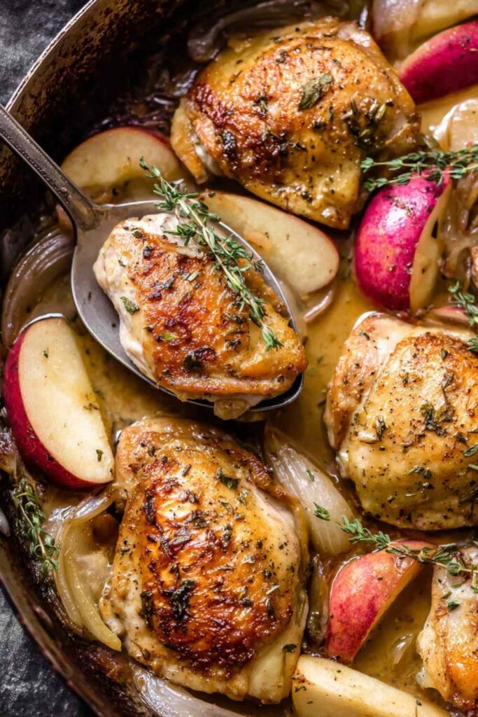 Apple chicken sheet pan dinner with caramelized brown sugar apples and onions on a rimmed baking sheet