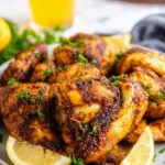 Beer can chicken recipe showing a whole grilled chicken balanced upright on a beer can with golden smoky paprika crust on an outdoor grill