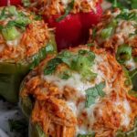 Buffalo Chicken Stuffed Peppers baked with melted cheddar cheese and sliced green onions on a sheet pan