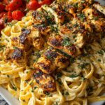 Creamy Cajun chicken linguine with garlic mozzarella sauce in a white bowl topped with fresh parsley