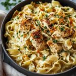 Chicken buttered noodles in a large skillet topped with fresh parsley and grated parmesan