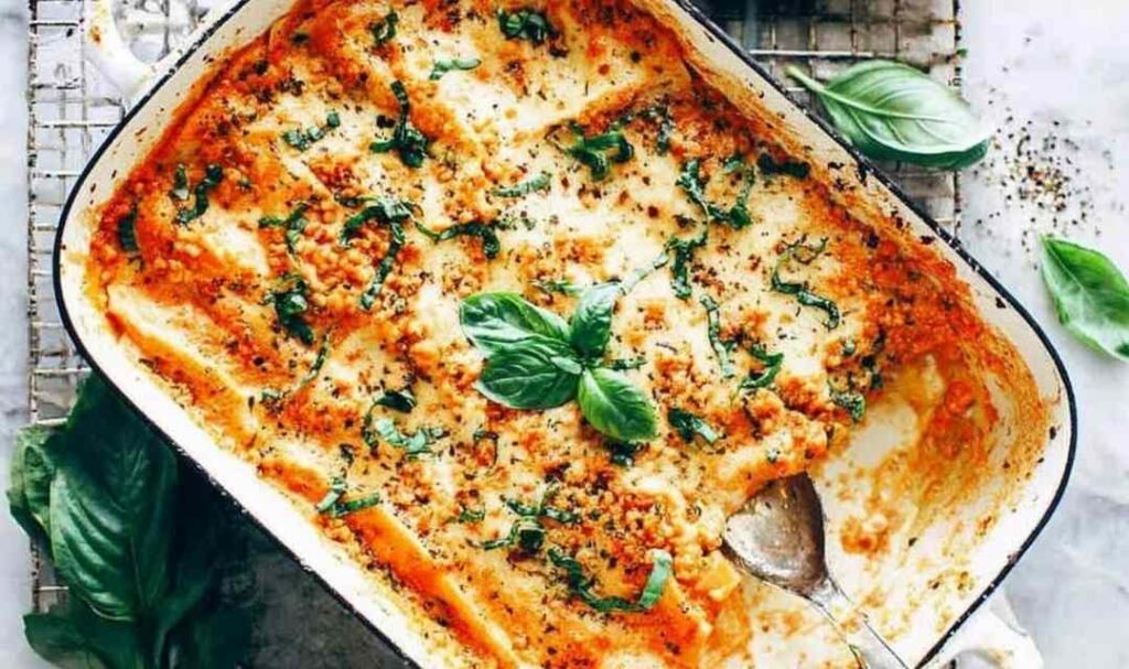 Chicken cannelloni baked in a creamy herb sauce in a white baking dish