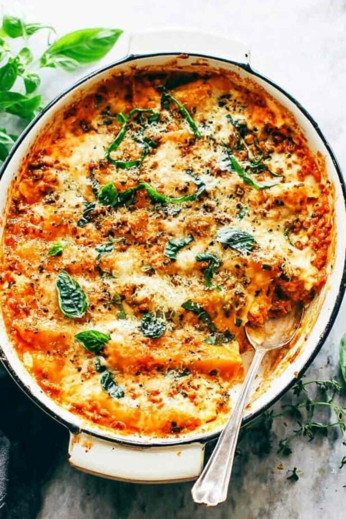 Chicken cannelloni baked in a creamy herb sauce in a white baking dish