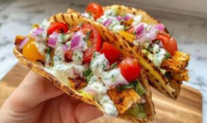 Chicken Gyros Smash Tacos Chicken Gyros Smash Tacos topped with tzatziki, cucumber, cherry tomatoes, and fresh coriander on a wooden board