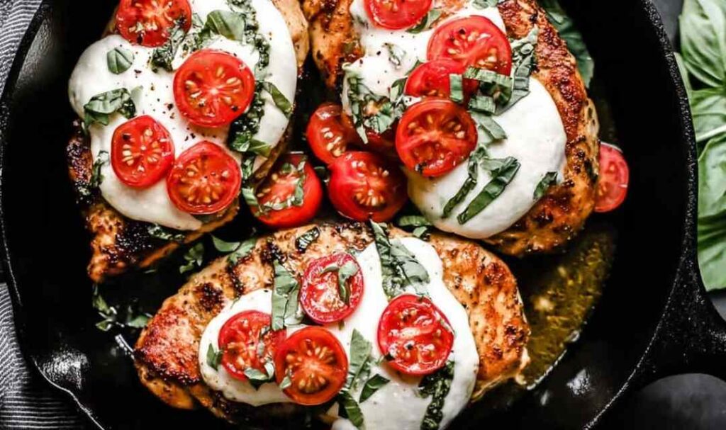 Chicken Margherita with melted fresh mozzarella and balsamic glaze in a cast iron skillet