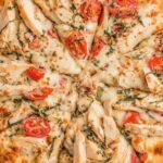 Chicken margherita pizza with grilled chicken slices, fresh basil, and melted mozzarella on a crispy golden crust