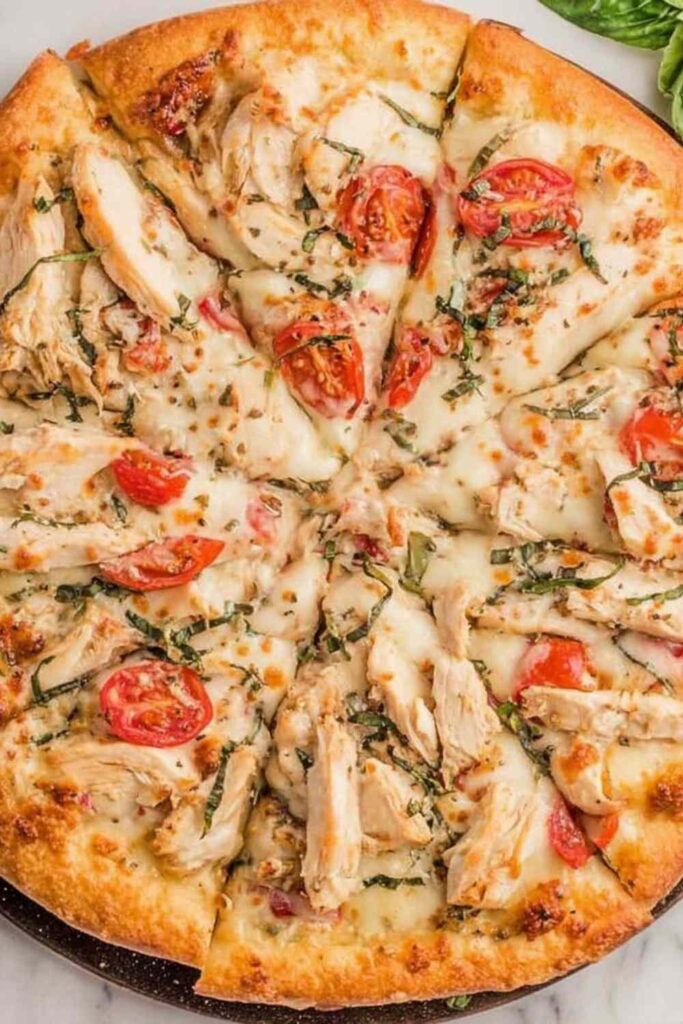 Chicken margherita pizza with grilled chicken slices, fresh basil, and melted mozzarella on a crispy golden crust