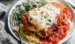 Crispy chicken Parmesan recipe with golden Panko crust, bubbling mozzarella, and marinara sauce in a baking dish