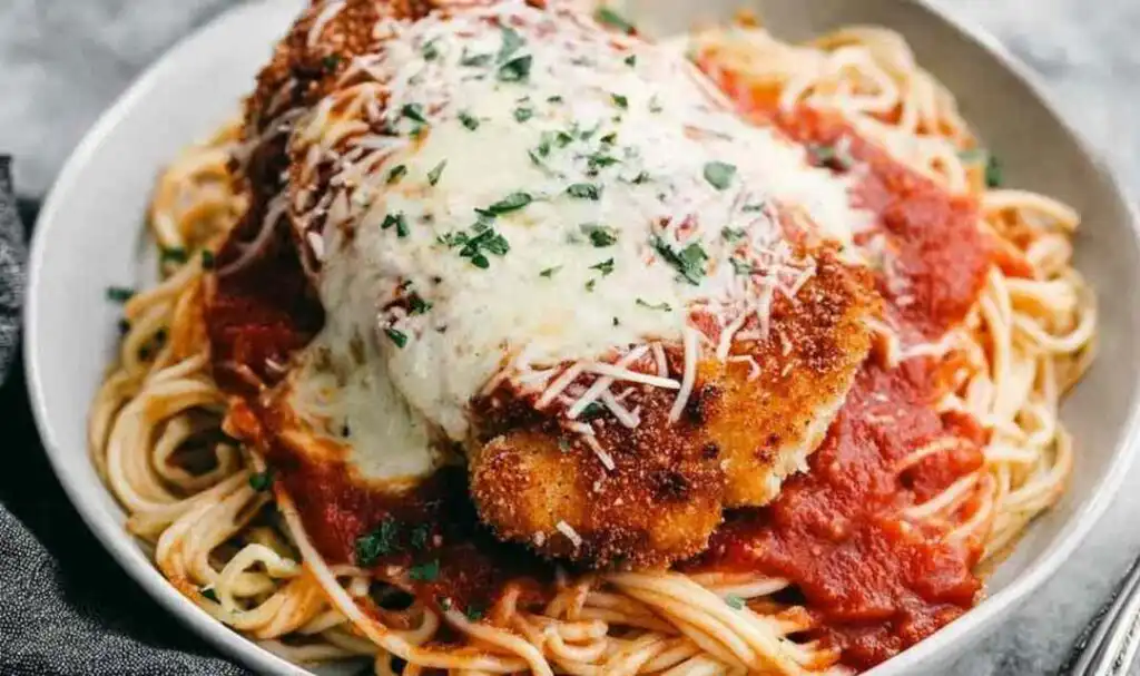 Crispy chicken Parmesan recipe with golden Panko crust, bubbling mozzarella, and marinara sauce in a baking dish