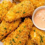 Golden baked cornflake chicken tenders on a wire rack served with creamy homemade special sauce