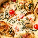 Creamy Tuscan chicken in a skillet with spinach, cherry tomatoes, and parmesan cream sauce
