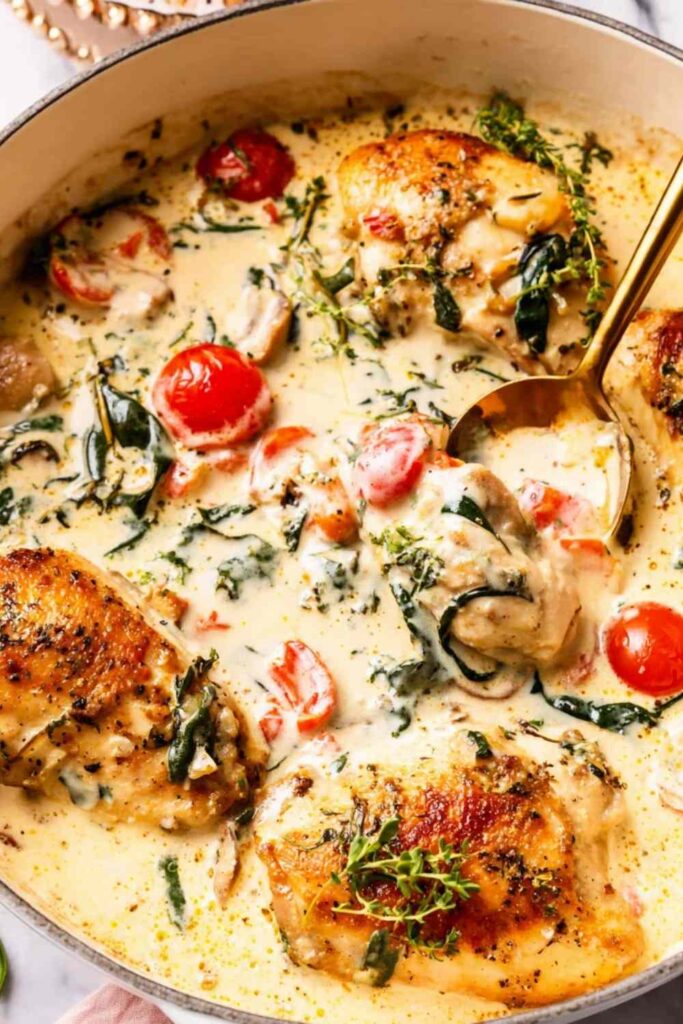 Creamy Tuscan chicken in a skillet with spinach, cherry tomatoes, and parmesan cream sauce