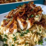 French Onion Chicken Orzo Casserole in a white baking dish with golden bubbly Gruyere cheese topping and fresh parsley garnish