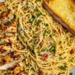 Garlic butter chicken pasta in a skillet with creamy Parmesan sauce and fresh parsley garnish