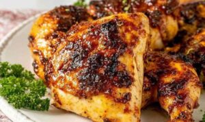 Grilled BBQ whole chicken pieces with caramelized barbecue glaze arranged on a serving platter