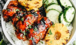 Grilled huli huli chicken recipe served with grilled pineapple and green onion garnish on a plate
