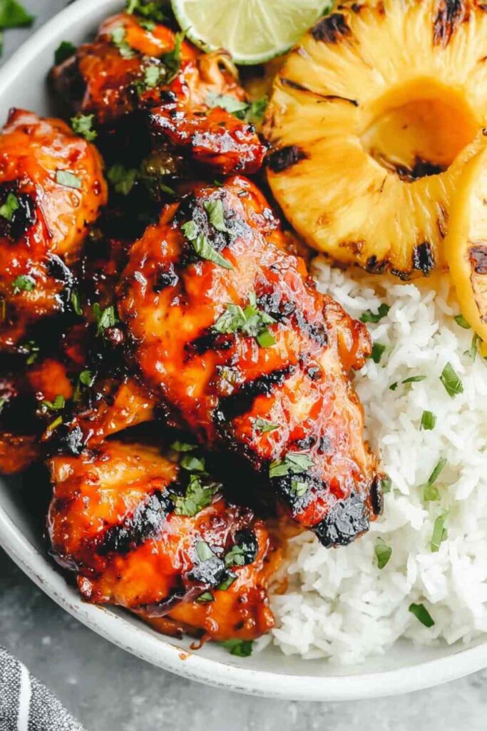 Grilled huli huli chicken recipe served with grilled pineapple and green onion garnish on a plate