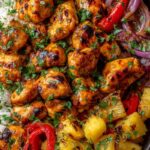 Hawaiian chicken sheet pan with caramelized pineapple chunks, red and yellow bell peppers, and teriyaki glaze on a parchment-lined baking sheet