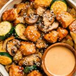 Hibachi chicken and vegetables in a skillet with golden seared chicken breast pieces, zucchini, mushrooms, carrots, and onion