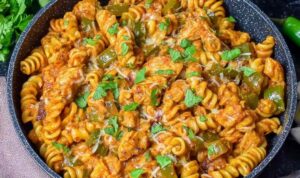 High protein chicken fajita pasta in a skillet with colorful bell peppers and creamy Greek yogurt sauce