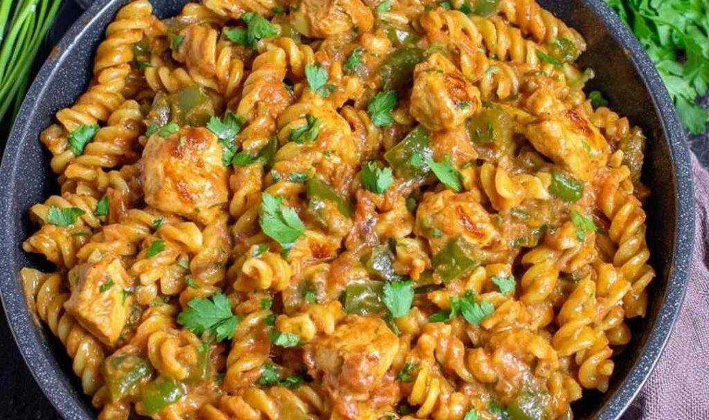 High protein chicken fajita pasta in a skillet with colorful bell peppers and creamy Greek yogurt sauce