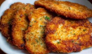 Crispy golden breaded chicken cutlets on a white plate ready to serve