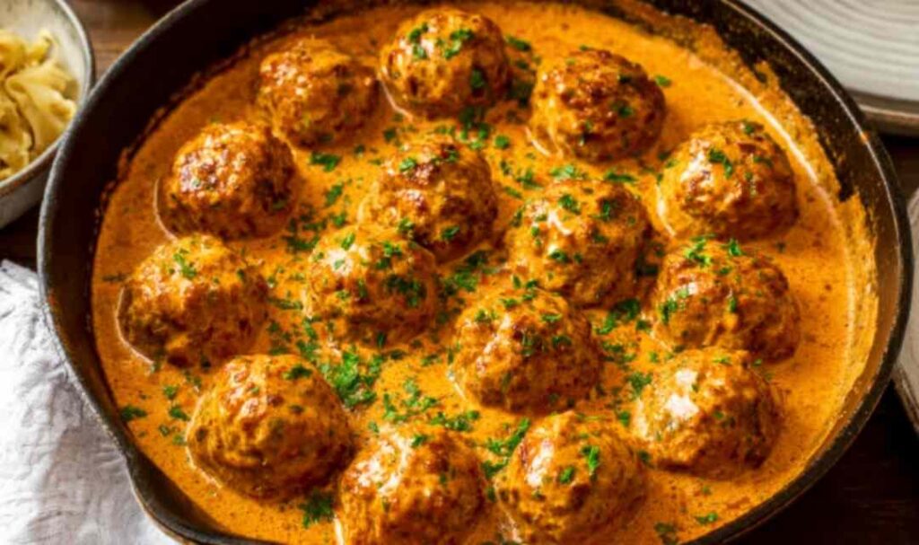 Hungarian paprikash chicken meatballs in silky sour cream paprika sauce served over buttered egg noodles