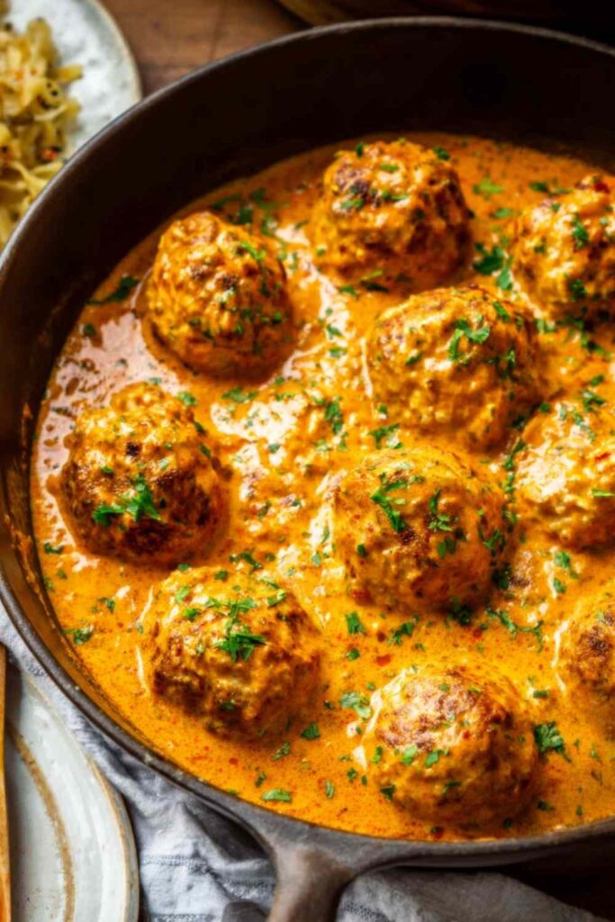 Hungarian paprikash chicken meatballs in silky sour cream paprika sauce served over buttered egg noodles