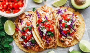 Instant Pot chicken tacos with juicy shredded chicken served in corn tortillas topped with Pico de Gallo and fresh avocado