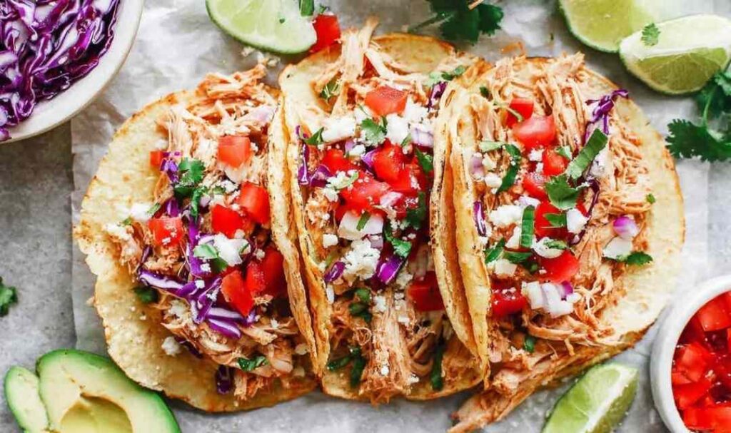 Instant Pot chicken tacos with juicy shredded chicken served in corn tortillas topped with Pico de Gallo and fresh avocado