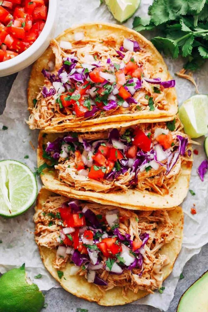 Instant Pot chicken tacos with juicy shredded chicken served in corn tortillas topped with Pico de Gallo and fresh avocado