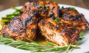 Bone-in grilled chicken thighs with crispy golden skin cooking on a grill grate