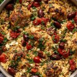 One-pot Mediterranean chicken orzo with cherry tomatoes, kalamata olives, and crumbled feta cheese in a Dutch oven