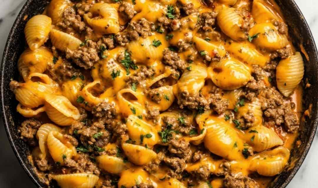 One-Pot Beef and Cheddar Ranch Pasta in a Dutch oven with creamy cheddar sauce and fresh chive garnish