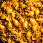 One-Pot Beef and Cheddar Ranch Pasta in a Dutch oven with creamy cheddar sauce and fresh chive garnish