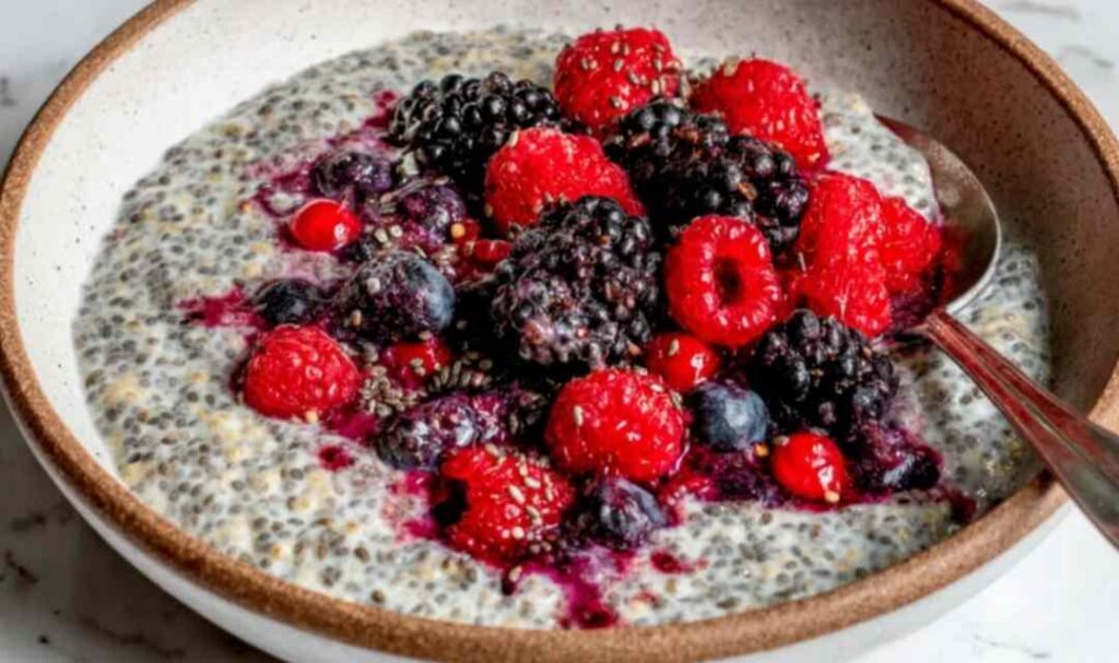 Overnight oats with mixed berries in a glass mason jar topped with fresh strawberries and blueberries
