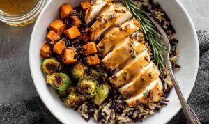 Maple Dijon chicken sheet pan dinner with crispy Brussels sprouts and roasted sweet potato on a large rimmed baking sheet