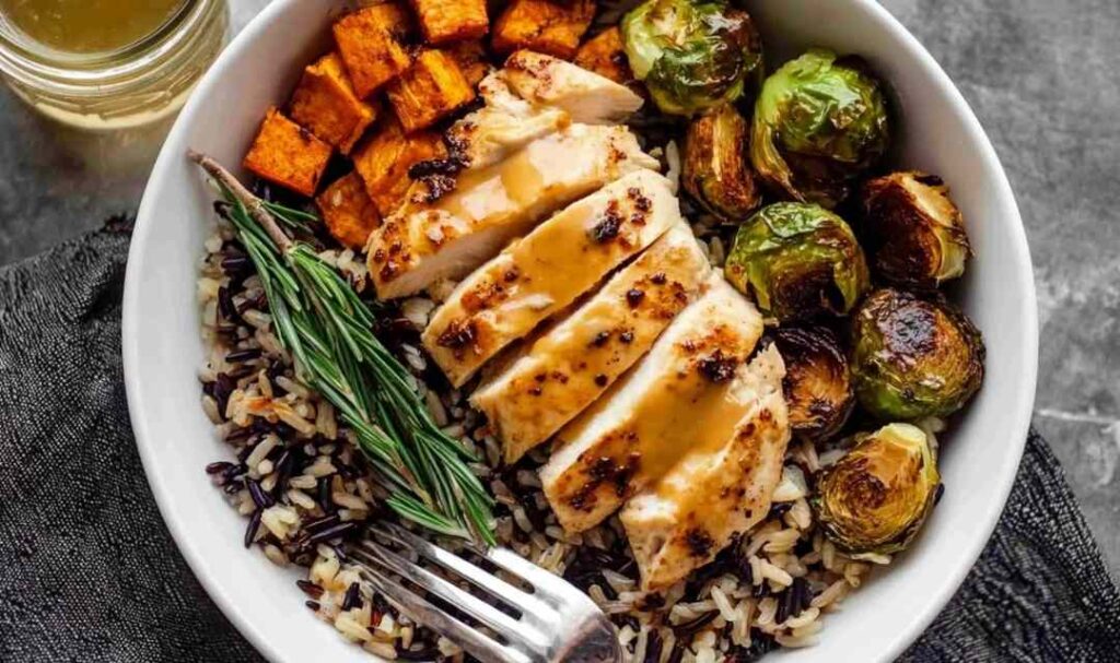 Maple Dijon chicken sheet pan dinner with crispy Brussels sprouts and roasted sweet potato on a large rimmed baking sheet
