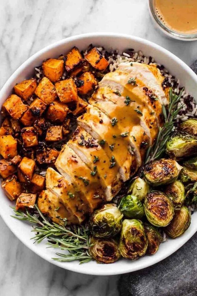 Maple Dijon chicken sheet pan dinner with crispy Brussels sprouts and roasted sweet potato on a large rimmed baking sheet
