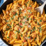 Creamy southwest chicken alfredo pasta in a skillet topped with fresh cilantro