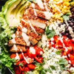 Southwest chicken salad with taco-seasoned chicken, avocado, black beans, corn, and chili lime dressing in a large bowl