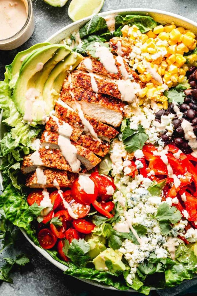 Southwest chicken salad with taco-seasoned chicken, avocado, black beans, corn, and chili lime dressing in a large bowl