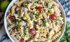 Southwest pasta salad with chipotle ranch dressing, grilled chicken, black beans, and corn in a large bowl