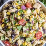 Southwest pasta salad with chipotle ranch dressing, grilled chicken, black beans, and corn in a large bowl