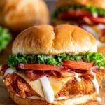 Crispy Asiago ranch chicken club sandwich stacked with bacon, lettuce, tomato, and melted Asiago cheese on a toasted bun